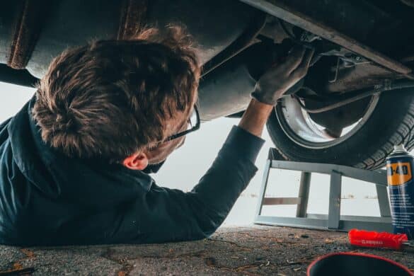 man underneath a car doing repairs